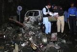 Police officials survey the site of a suicide bomb explosion in Pakistan