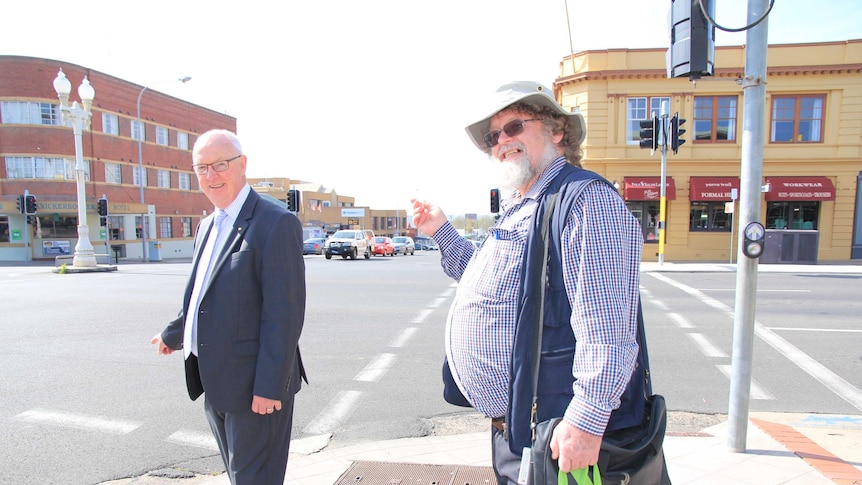 Two men on the intersection of a street in a country town