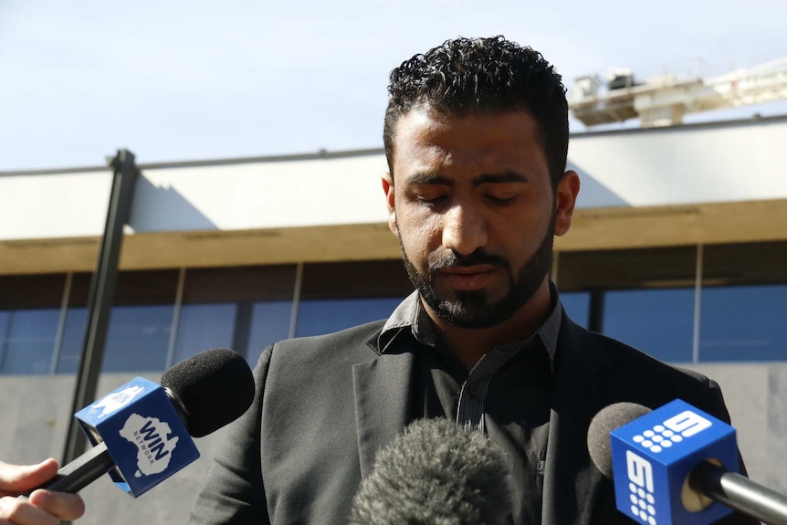 Salah Al Mdwali reads a statement to the media.