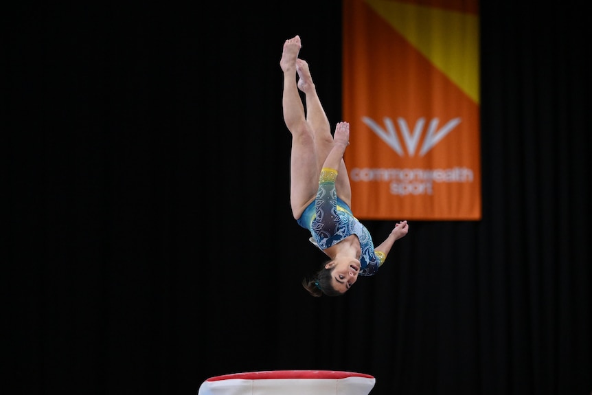 A female gymnast does a flip