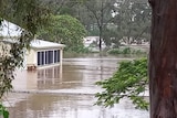 A building about half-submerged in floodwater.