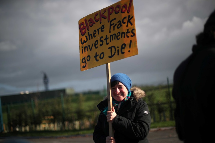 protester holds up a sign reading blackpool where frack investments go to die