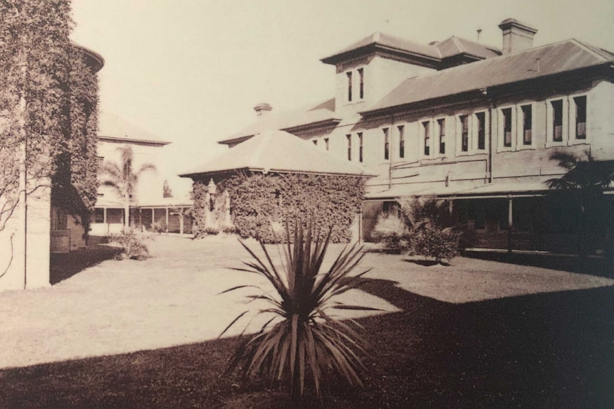 A black and white photo of a large building with a series of windows.