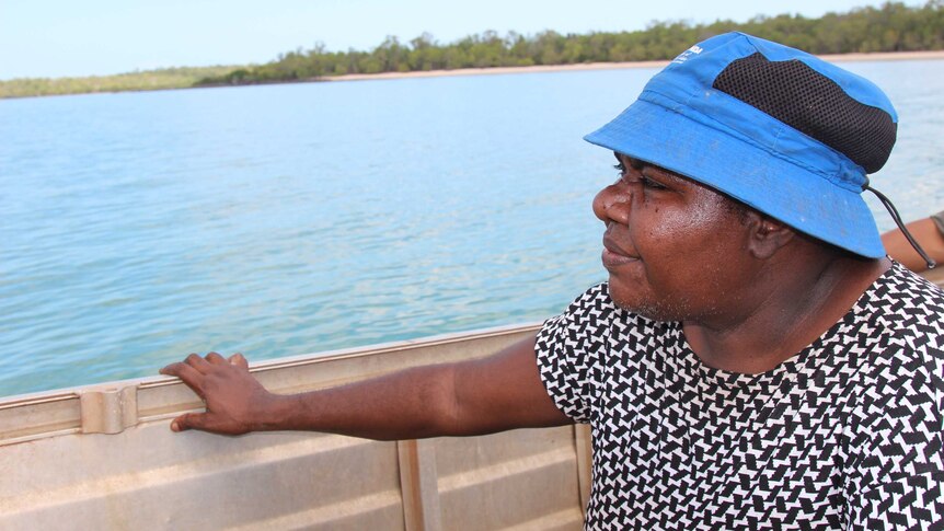 A woman in a blue hat sitting in a boat.