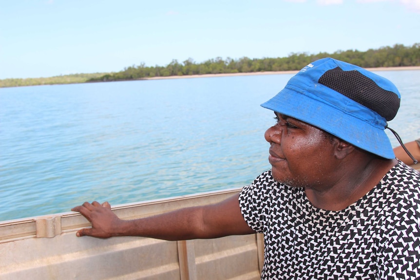 A woman in a blue hat sitting in a boat.