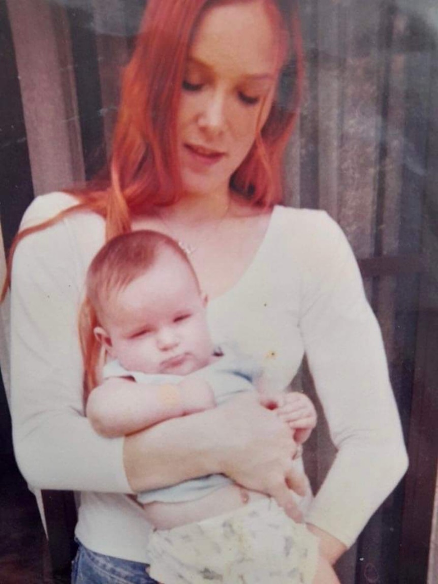 Червенокоса жена държи бебе