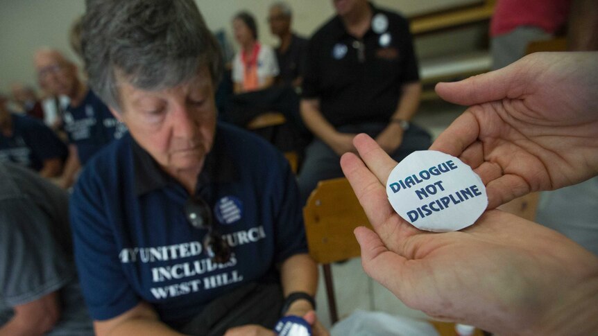 Supporters put stickers on some buttons prior to a meeting between Gretta Vosper and United Church officials.