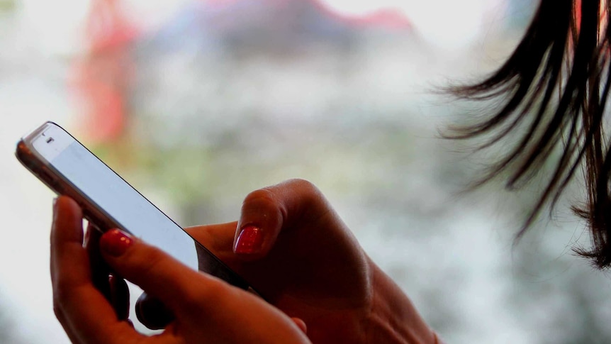 A close-up of an unidentified woman texting on an iPhone.