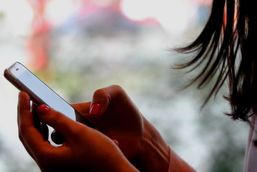 A close-up of an unidentified woman texting on an iPhone.