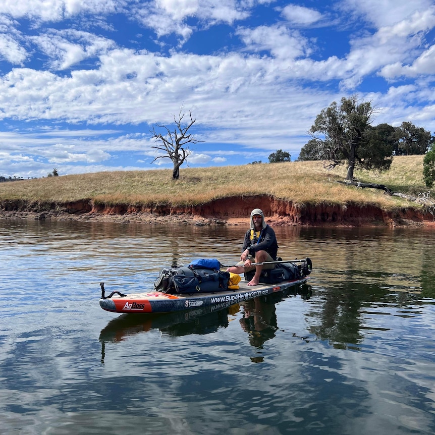 Peter Charlesworth sits on his paddleboard on the Murray River