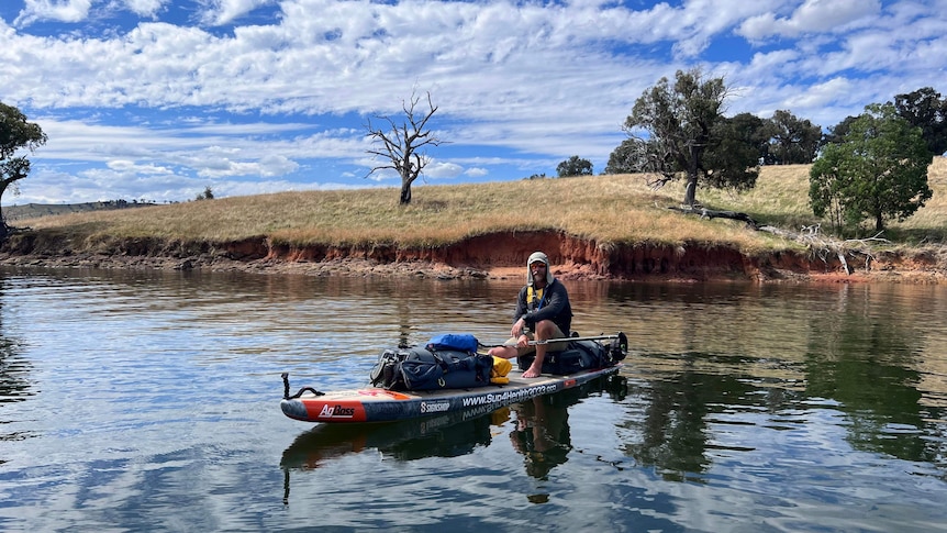 Peter Charlesworth sits on his paddleboard on the Murray River