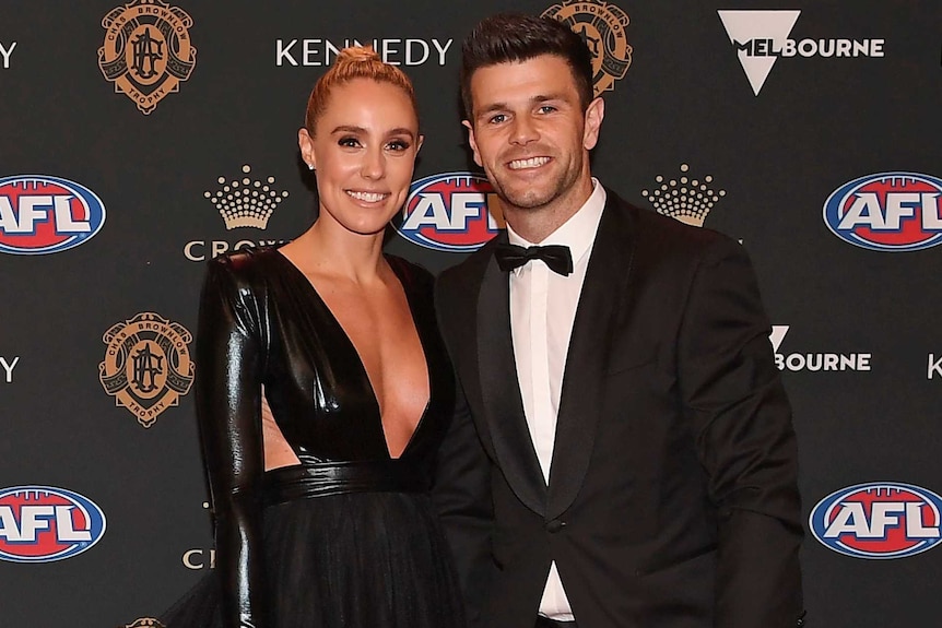 Brooke and Trent Cotchin, dressed to the nines, smile for a photo on the Brownlow Medal red carpet