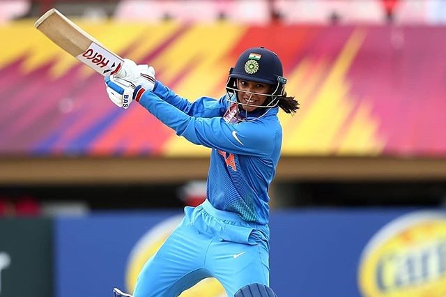 Indian cricketer Smriti Mandhana hits a cover drive while batting.