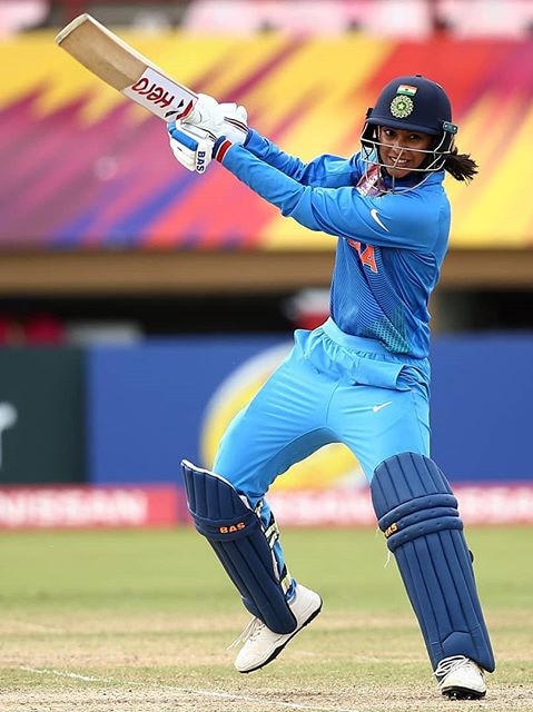 Indian cricketer Smriti Mandhana hits a cover drive while batting.