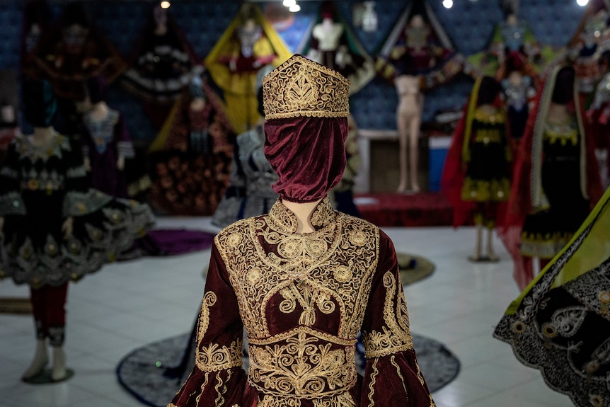 A mask of red velvet with a gold crown on a mannequin in Kabul.