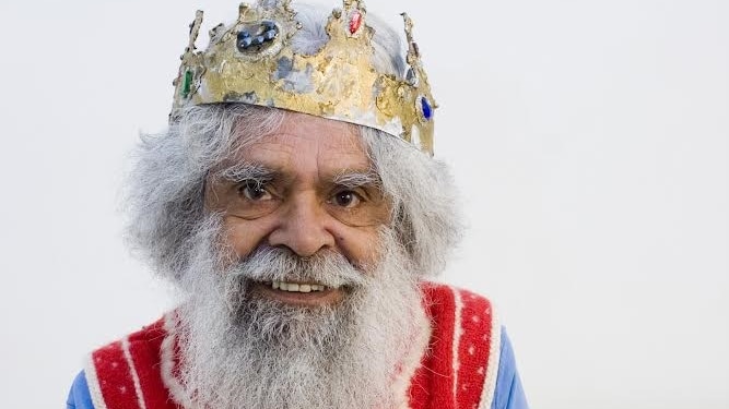 a man with a grey beard wearing a crown.