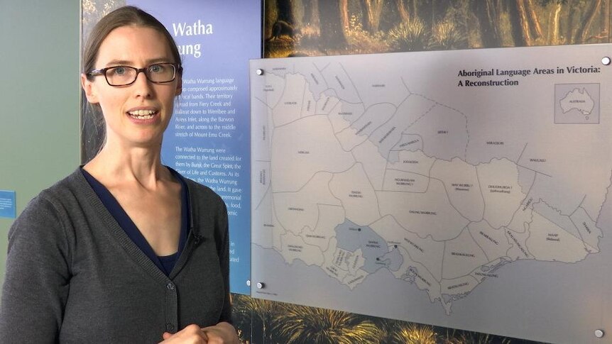 Woman stands in front of Aboriginal Language Ares in Victoria map