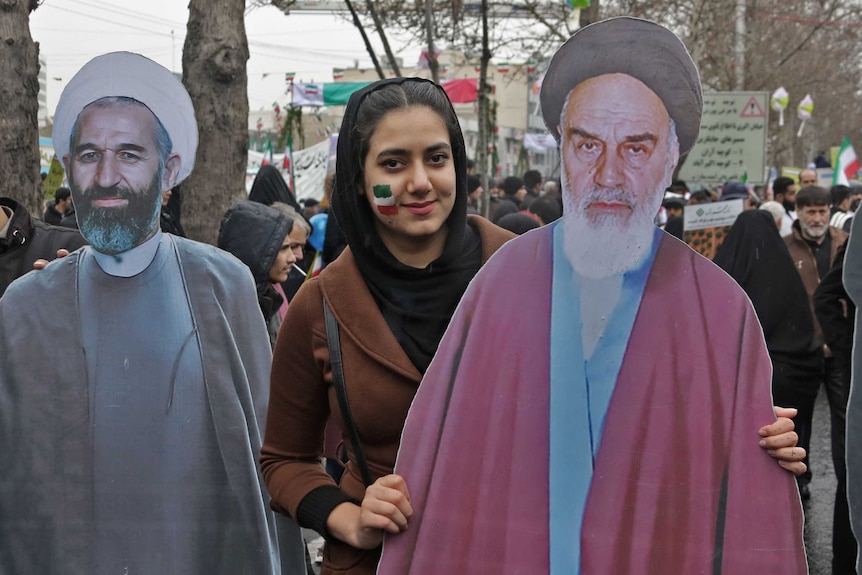 An Iranian woman poses with a life-size cutout of Khomeini during celebrations of the 40th anniversary of the revolution.