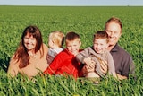 Smiling family photo in grain crop