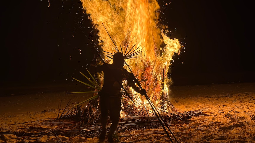 A man performing a ritual as part of Wogasia festival, symbolising his house on fire. 