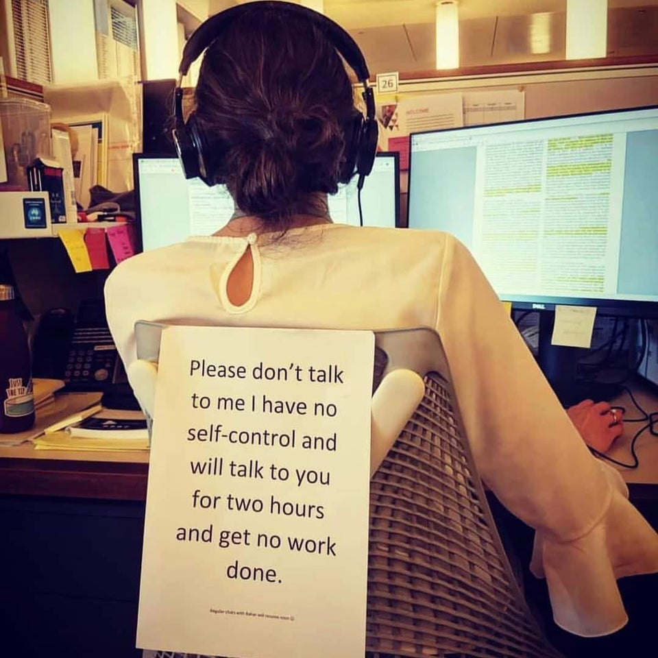 A woman with a sign on her shirt saying: "Please don't talk to me I have no self-control and will talk to you for two hours."