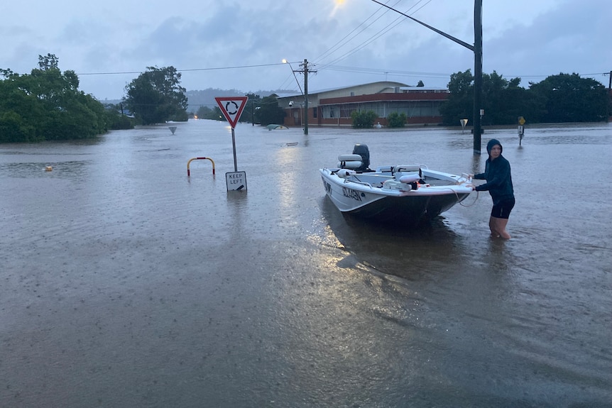 woman pulling speed boat through a flooded street