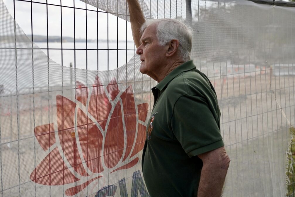 a amn who regularly swam at nielsen park in sydney looks through the mesh that covers the site as remedial work is done