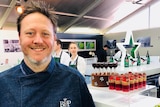 Chef Darren Purchese stands in front of a table of desserts in a photo from the business's Instagram account.