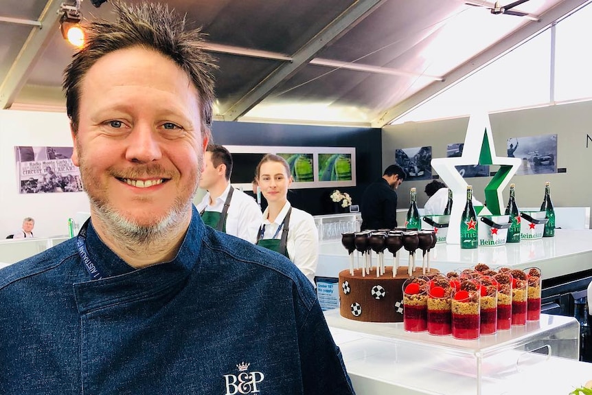 Chef Darren Purchese stands in front of a table of desserts in a photo from the business's Instagram account.