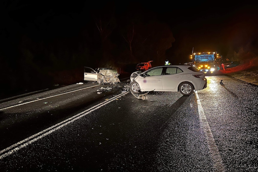 Nighttime photo of two cars in highway accident