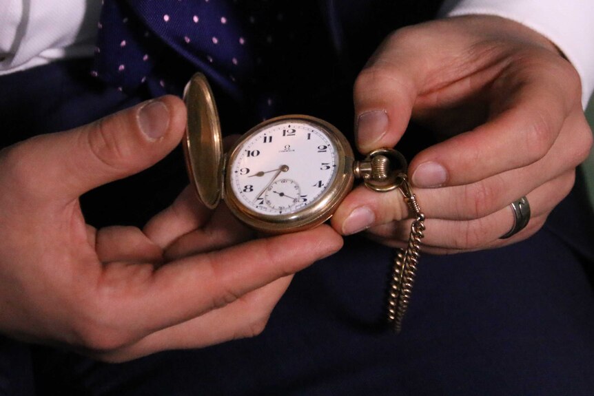 Tim Wilson holds a pocket watch to check the time before Question Time.