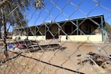 A chain link fence surrounds a house in an Aboriginal camp