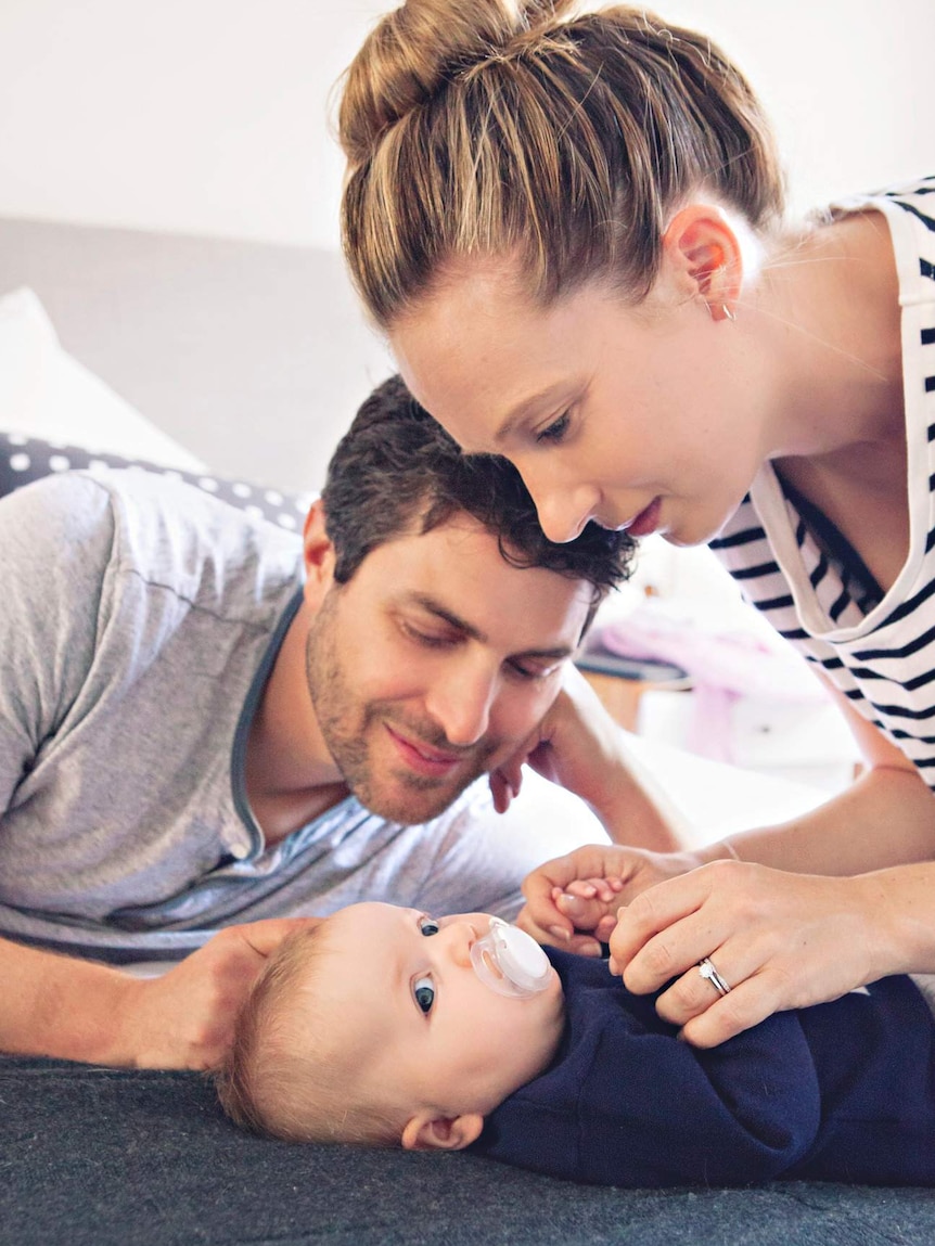 Rachael and Jonny Casella with Mackenzie playing on the floor.