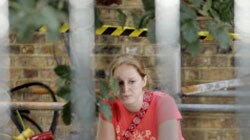 A girl cries near flowers left in memory of victims of bomb attacks at Kings Cross station