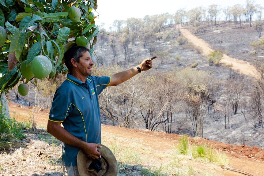 Jeff Pershouse points to the damage caused by bushfires at The Caves, north of Rockhampton, on November 30, 2018.