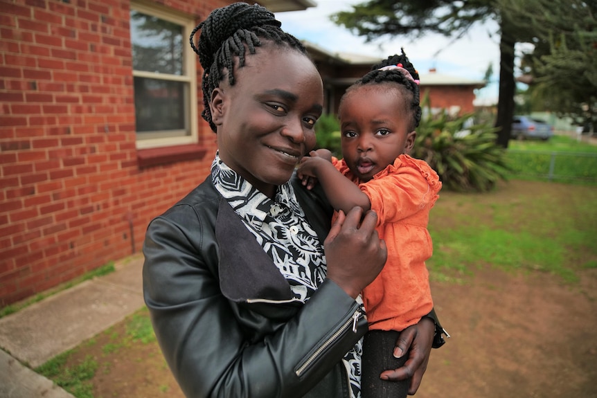 A woman holding her young daughter.