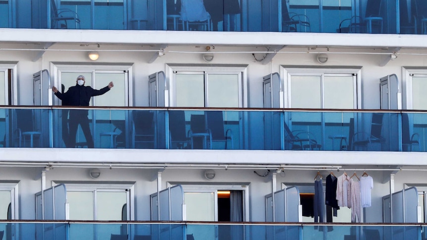 A few passengers on balconies on a cruise ship
