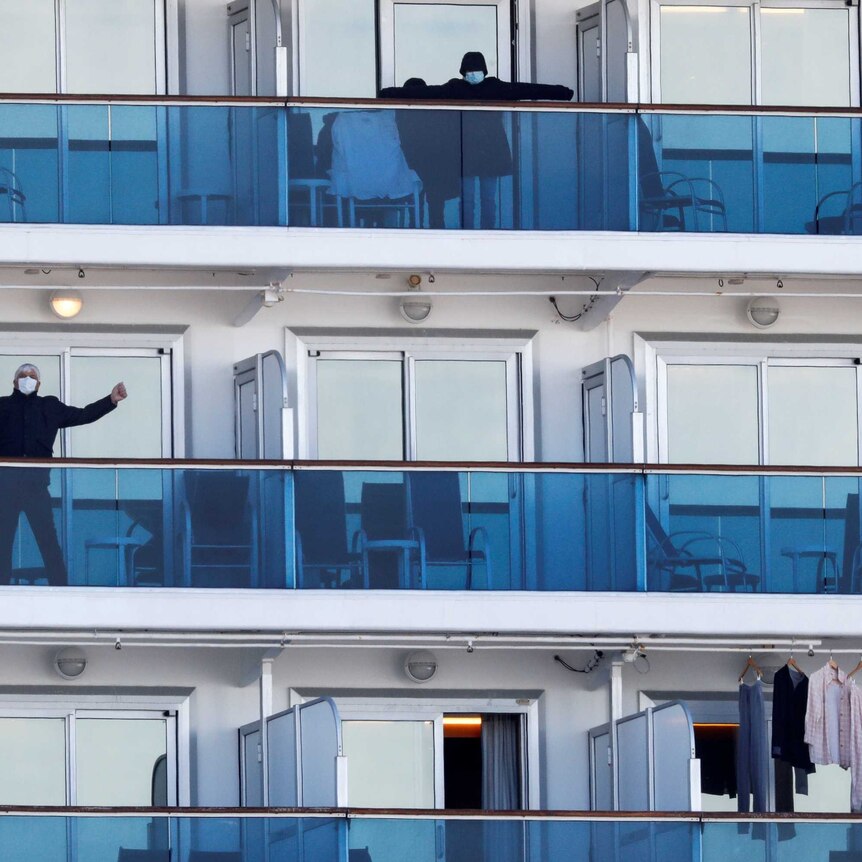 A few passengers on balconies on a cruise ship