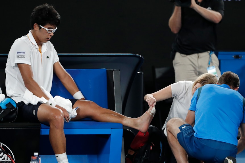 Hyeon Chung receives treatment from a trainer on his left foot for blisters in the Australian Open semi-final.