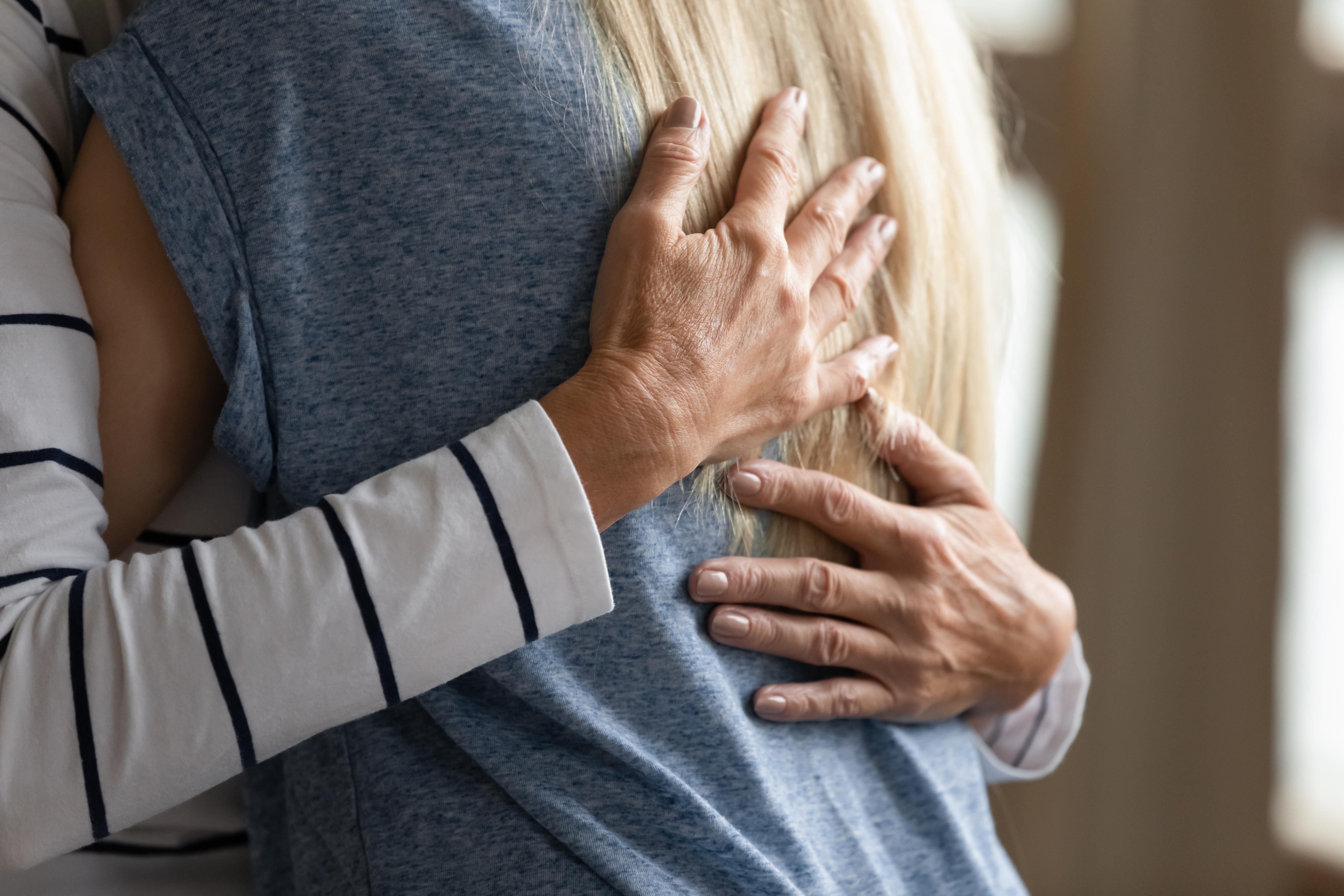 Close up image elderly woman hugs younger relative girl