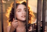 Madonna peers through an iron gate in the clip for Like A Prayer.