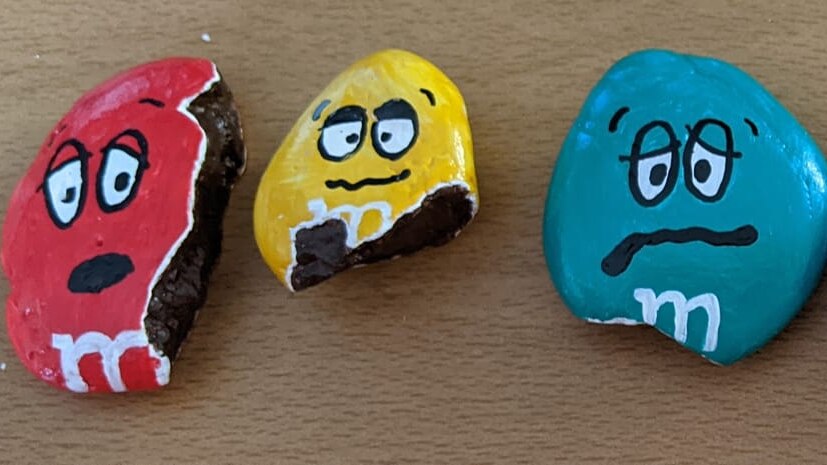 Three painted rocks resemble the M&M characters. 