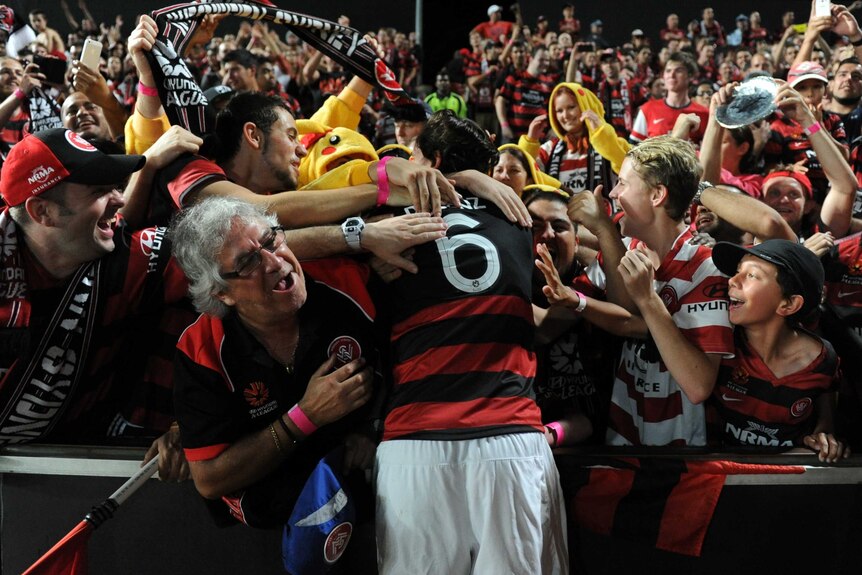 Joyous moments ... Wanderers fans embrace Jerome Polenz after the final whistle.