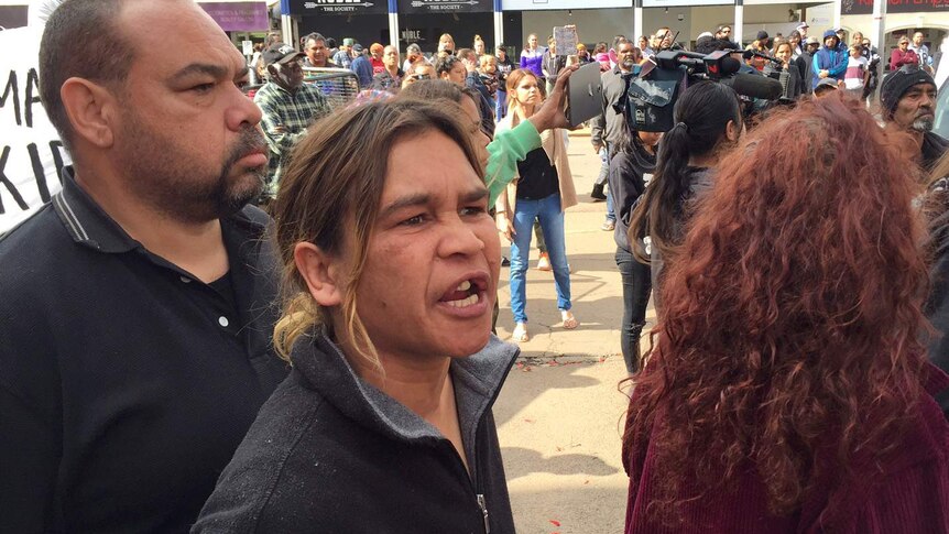 A woman shouts while standing in front of a group of protesters on Hannan Street in Kalgoorlie.