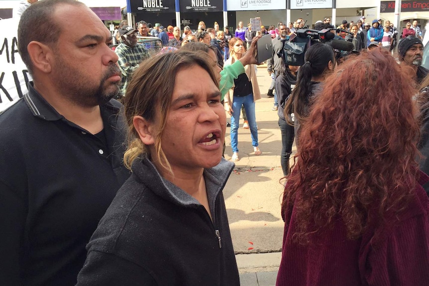 A woman shouts while standing in front of a group of protesters on Hannan Street in Kalgoorlie.