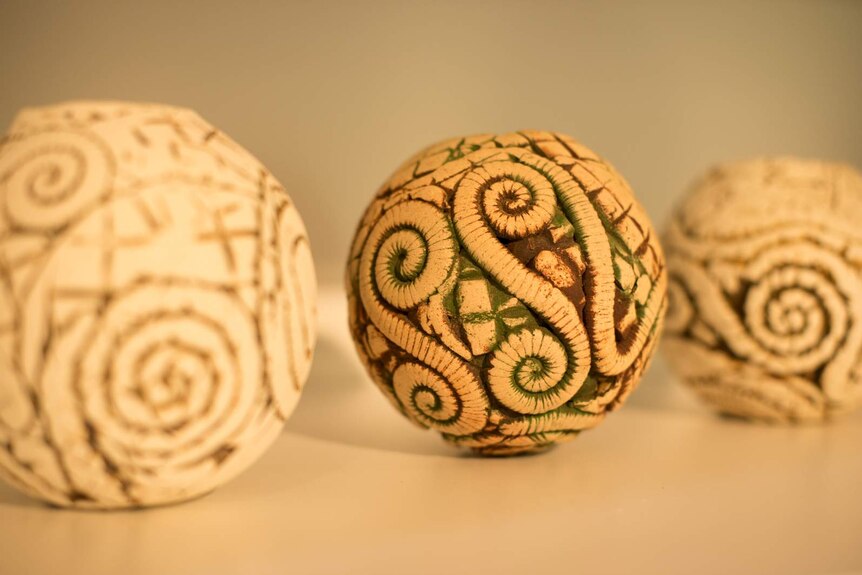 Three seashell inspired pots on a display shelf at the Yarrabah Arts Centre.