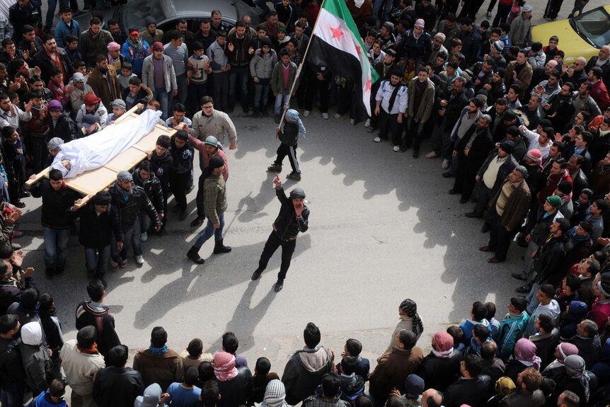 Syrian mourners carry slain youth