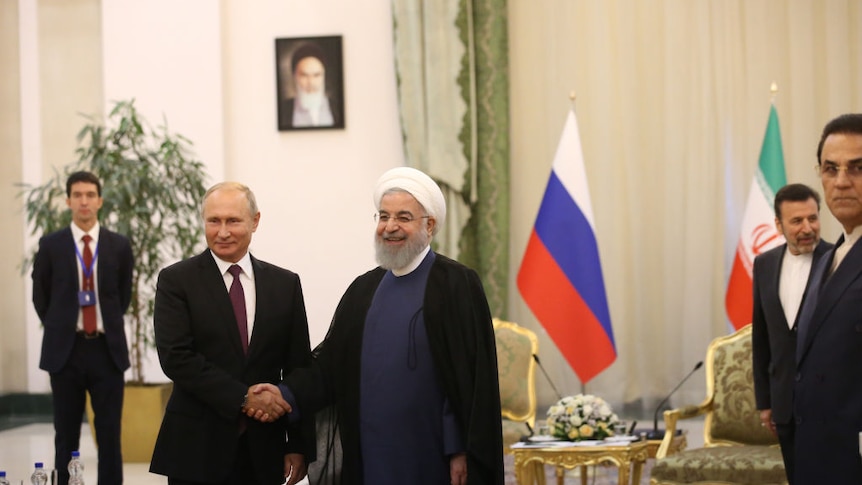 Russian president shakes hands with Iran president during bilaterals talks at the Trilateral Summit Iran-Russia-Turkey