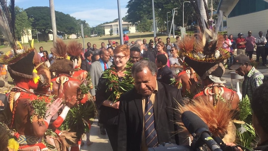 Foreign Minister Marise Payne walks between dancers in traditional dress in Bougainville on her 2019 state visit