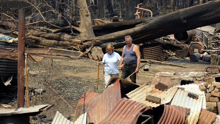 Judy and Kevin Purtzel survey the bushfire damage on their property near Marysville.